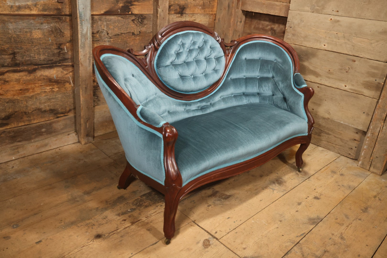 Antique Victorian Carved Walnut Settee With Tufted Blue Upholstery And Casters