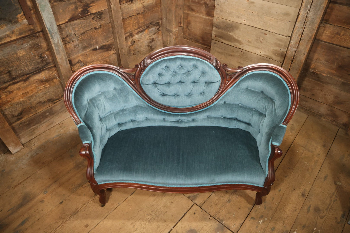Antique Victorian Carved Walnut Settee With Tufted Blue Upholstery And Casters