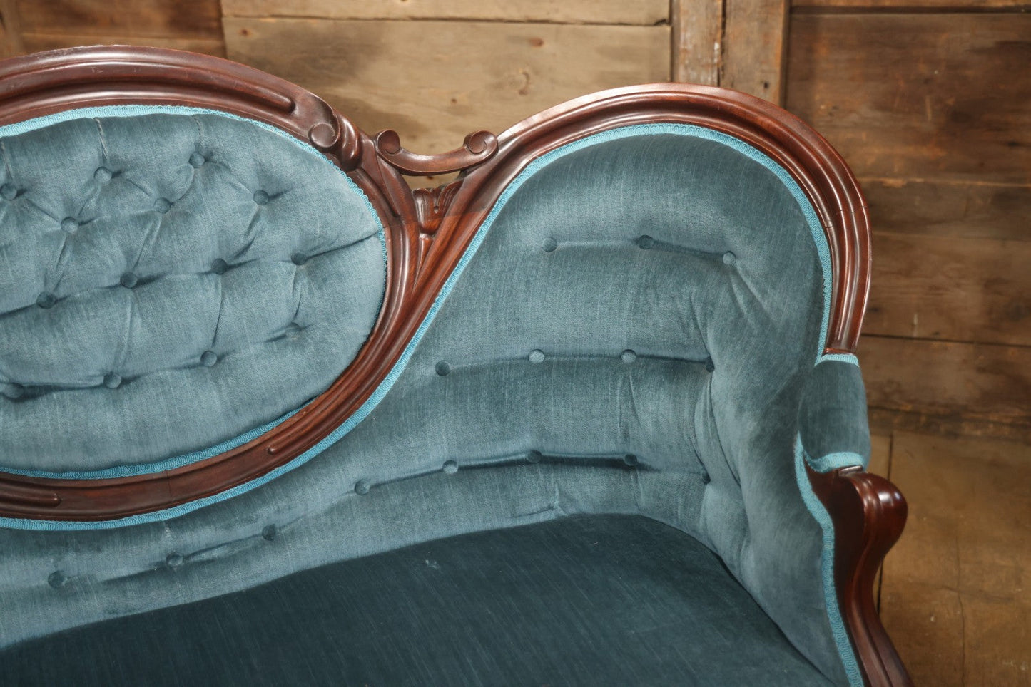 Antique Victorian Carved Walnut Settee With Tufted Blue Upholstery And Casters