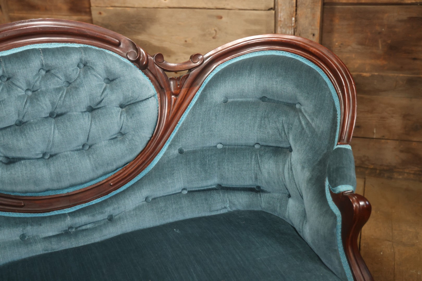 Antique Victorian Carved Walnut Settee With Tufted Blue Upholstery And Casters