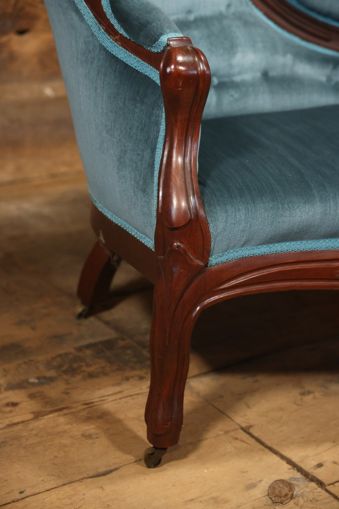 Antique Victorian Carved Walnut Settee With Tufted Blue Upholstery And Casters