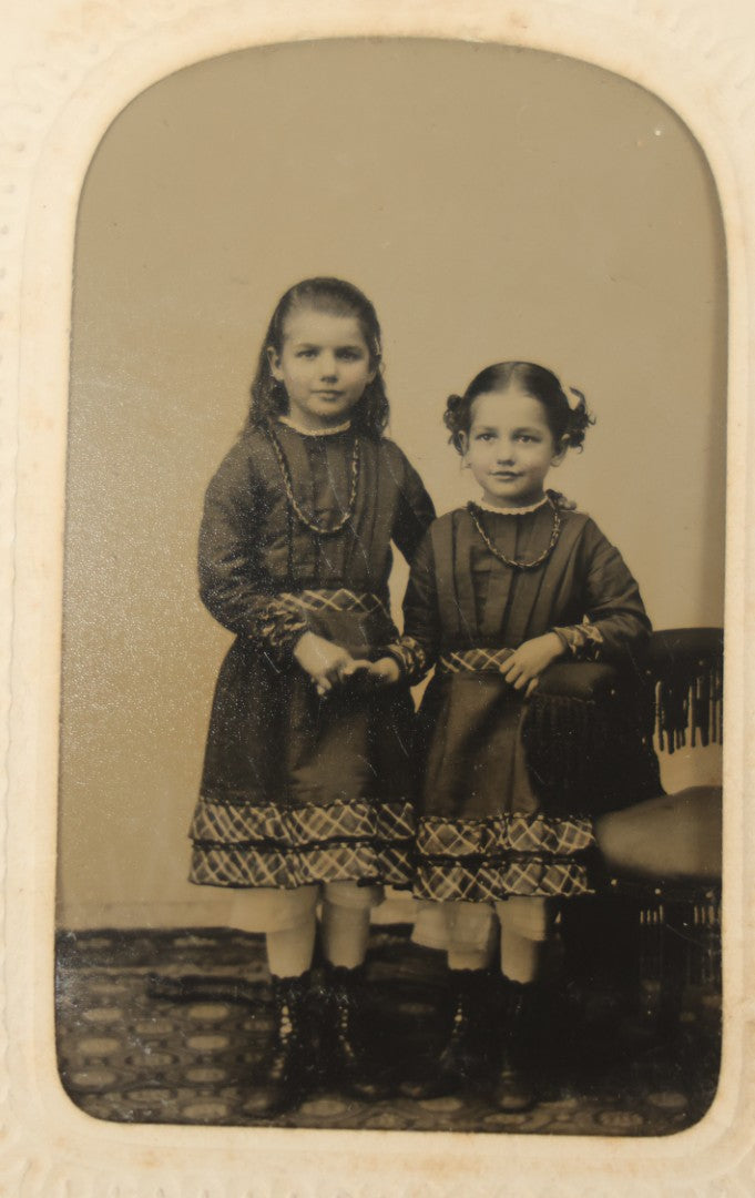 Lot 018 - Antique Tintype Photograph Of Two Smiling Sisters In Matching Outfits Holding Hands, In Paper Frame, Photographed By A.E. Alden, Springfield, Massachusetts
