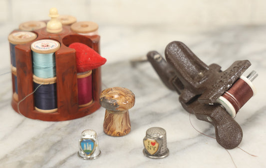 Lot 107 - Antique And Vintage Sewing Lot Including Marbled Plastic Thread Holder With Pin Cushion, Metal Mushroom Thread Holder, Two Thimbles, And Cast Iron Table Clamp Thread Holder By Herter's, Waseca Minn., No. 29