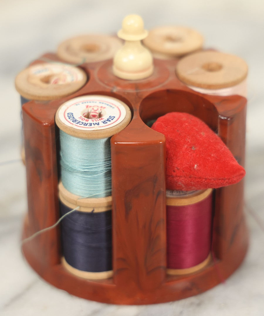 Lot 107 - Antique And Vintage Sewing Lot Including Marbled Plastic Thread Holder With Pin Cushion, Metal Mushroom Thread Holder, Two Thimbles, And Cast Iron Table Clamp Thread Holder By Herter's, Waseca Minn., No. 29