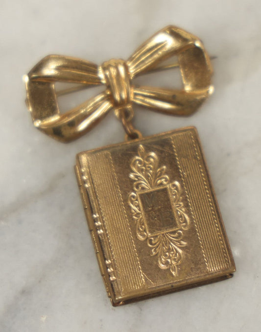 Lot 123 - Vintage Gold-Tone Bow Brooch With Dangling Book-Form Locket Monogrammed “M & B”