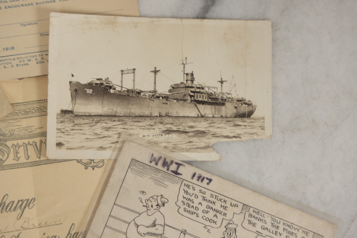 Lot 190 - Grouping Of Seven Antique World War I Related Ephemera Items Including Discharge Papers For John Joseph Breen And Michael J. Breen, Comic Postcard, And War Savings Stamps Forms, Circa 1910s–1920s