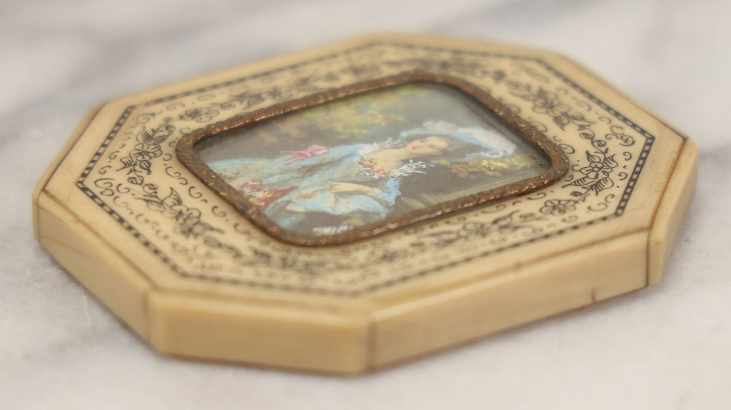 Lot 004 - Antique Miniature Print with Painted Details Of Fancy Woman In Blue, In Bone Frame, Signed "Zuley", With Brass Lip Around Glass, Fabric Cover On Verso, Frame Decorated With Painted Black Flower Border, 3" x 3-5/8"