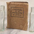 Lot 041 - Grouping Of Two Miniature Narrow Clear Glass Bottles And "Confessions Of An Opium Eater" Antique Miniature Book With Paper Cover And Advertising For Whitman's Candy In Rear, Published By Little Leather Library Corporation, New York, Circa 1920