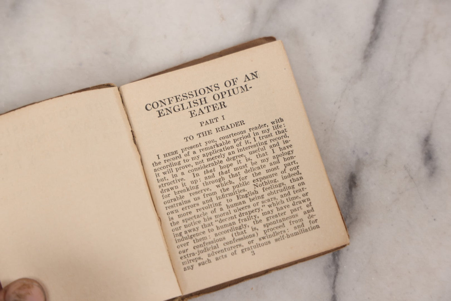 Lot 041 - Grouping Of Two Miniature Narrow Clear Glass Bottles And "Confessions Of An Opium Eater" Antique Miniature Book With Paper Cover And Advertising For Whitman's Candy In Rear, Published By Little Leather Library Corporation, New York, Circa 1920