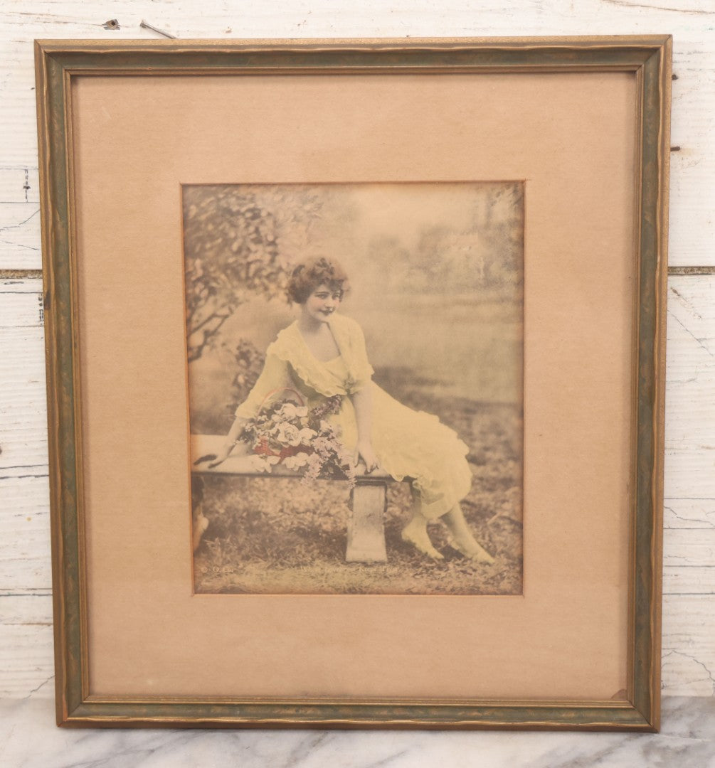 Lot 058 - Antique Framed Hand-Tinted Art Photo Print, "Where Loveliness Keeps Tryst," Featuring Woman In Yellow Dress On Bench With Flowers, Copyright O. Co., 11-1/2" x 13"