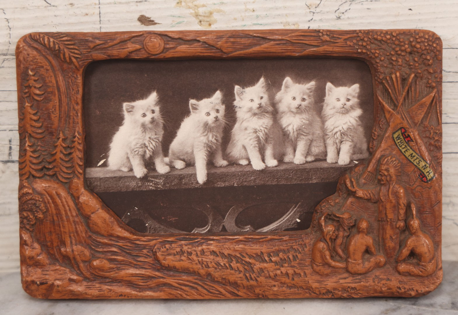 Lot 064 - Antique Molded Composite Photo Frame With Native American Motif, Souvenir Of White Mountains, New Hampshire, With Black And White Photo Postcard Of Five Kittens, 7-3/8" x 4-5/8"