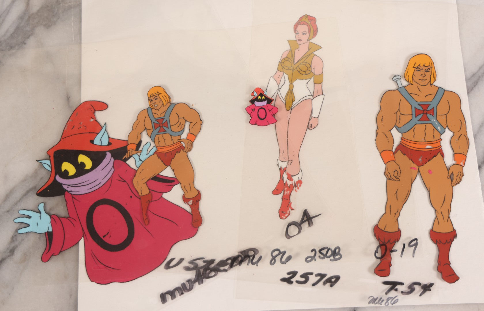 Lot 079 - Grouping Of Five Original Reverse-Painted Production Character Animation Cels On Celluloid From 1983 Cartoon "He-Man And The Masters Of The Universe," He-Man (2), Orko (2), And Teela (1)