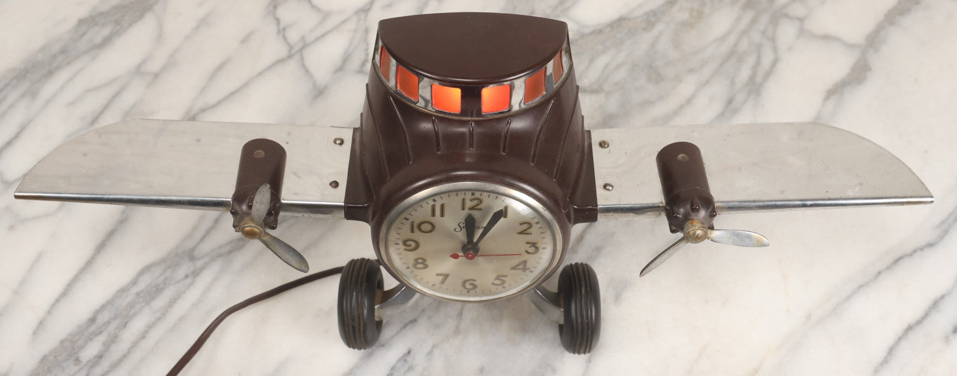 Lot 011 - Vintage Bakelite Airplane Form Clock With Internal Lamp, Note Clock Does Not Work And Both Propellers Missing One Blade
