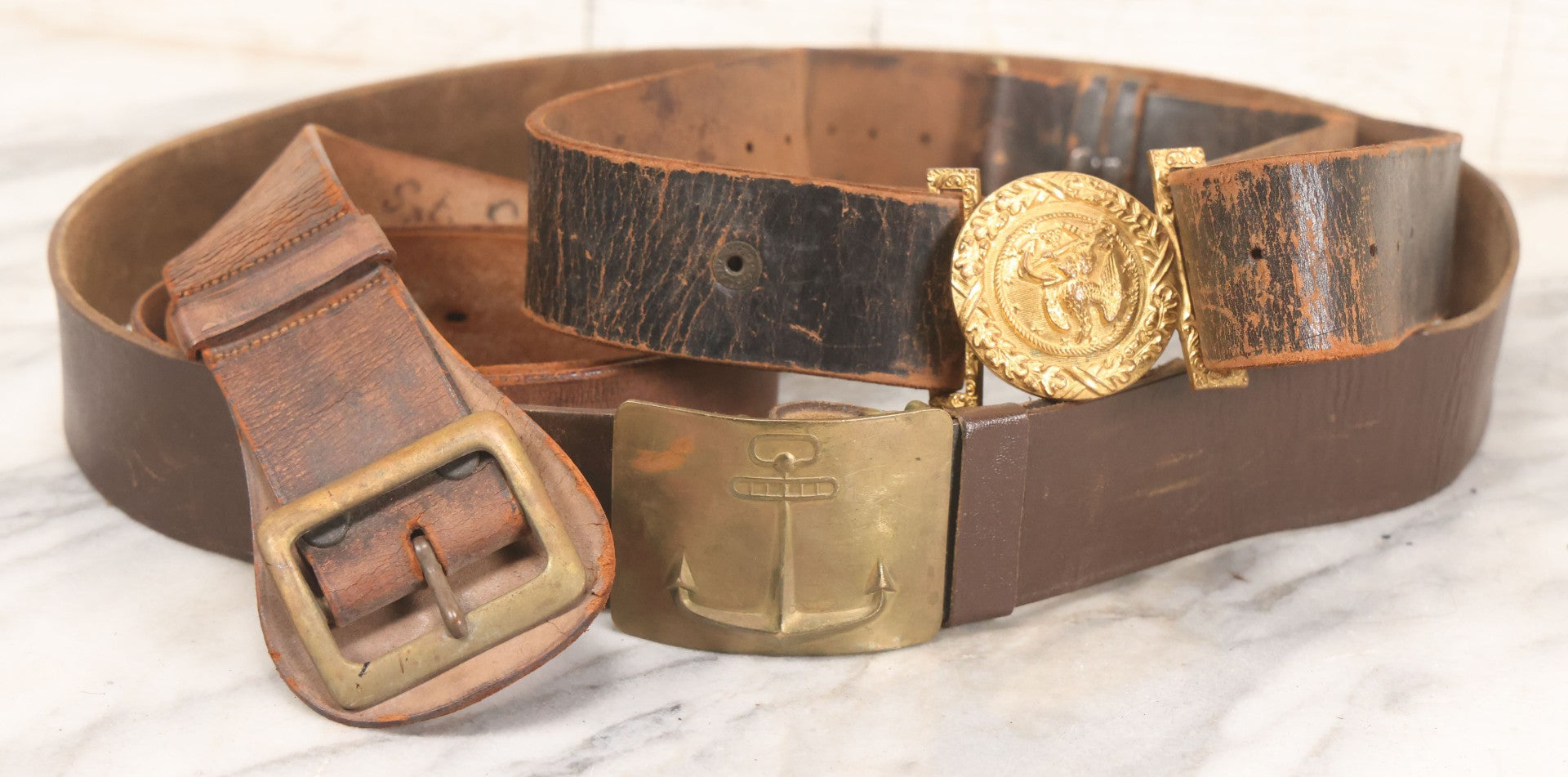 Lot 060 - Trio Of Antique Leather Belts Including Brass Anchor Buckle, Brass Eagle-And-Anchor Buckle, And Belt Marked “Sgt. Standish, Co. L. 182nd Inf.”