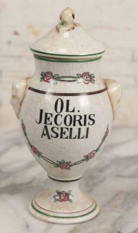 Lot 075 - Vintage Handarbeit Apothecary Pharmacy Lidded Jar Fantasy Reproduction "Ol. Jecoris Aselli" (Cod Liver Oil) With Craquelure Finish, Hand-Painted Roses, Figural Raised Heads On Sides, Unmarked, 7-1/4" H