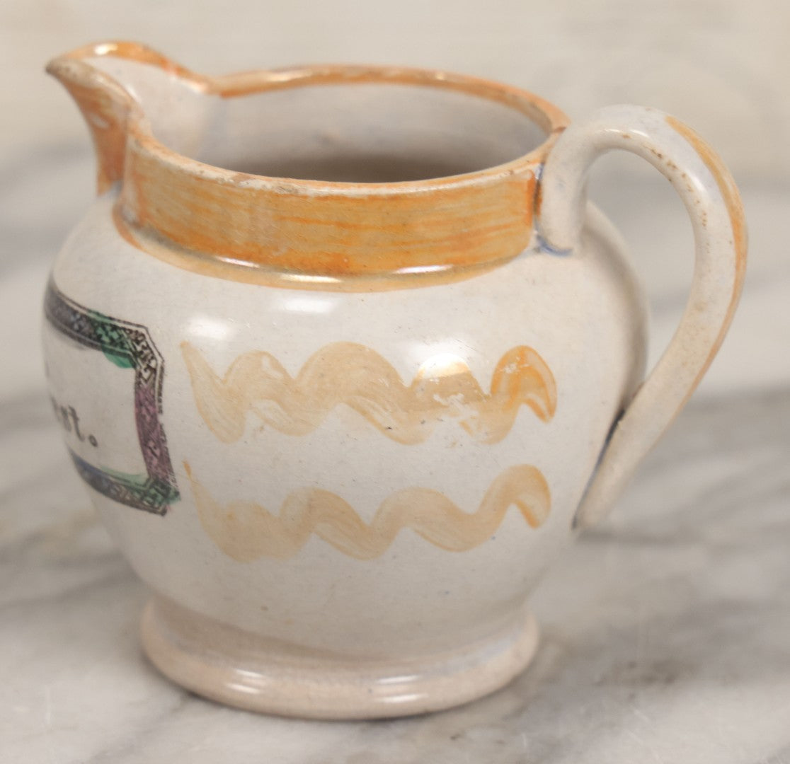 Lot 076 - Antique Hand Colored Transferware Creamer With "Do Thy Best, And Leave The Rest." Motto, Metallic Orange Paint On Sides, Handle And Rim, Unmarked, 3-3/8" H