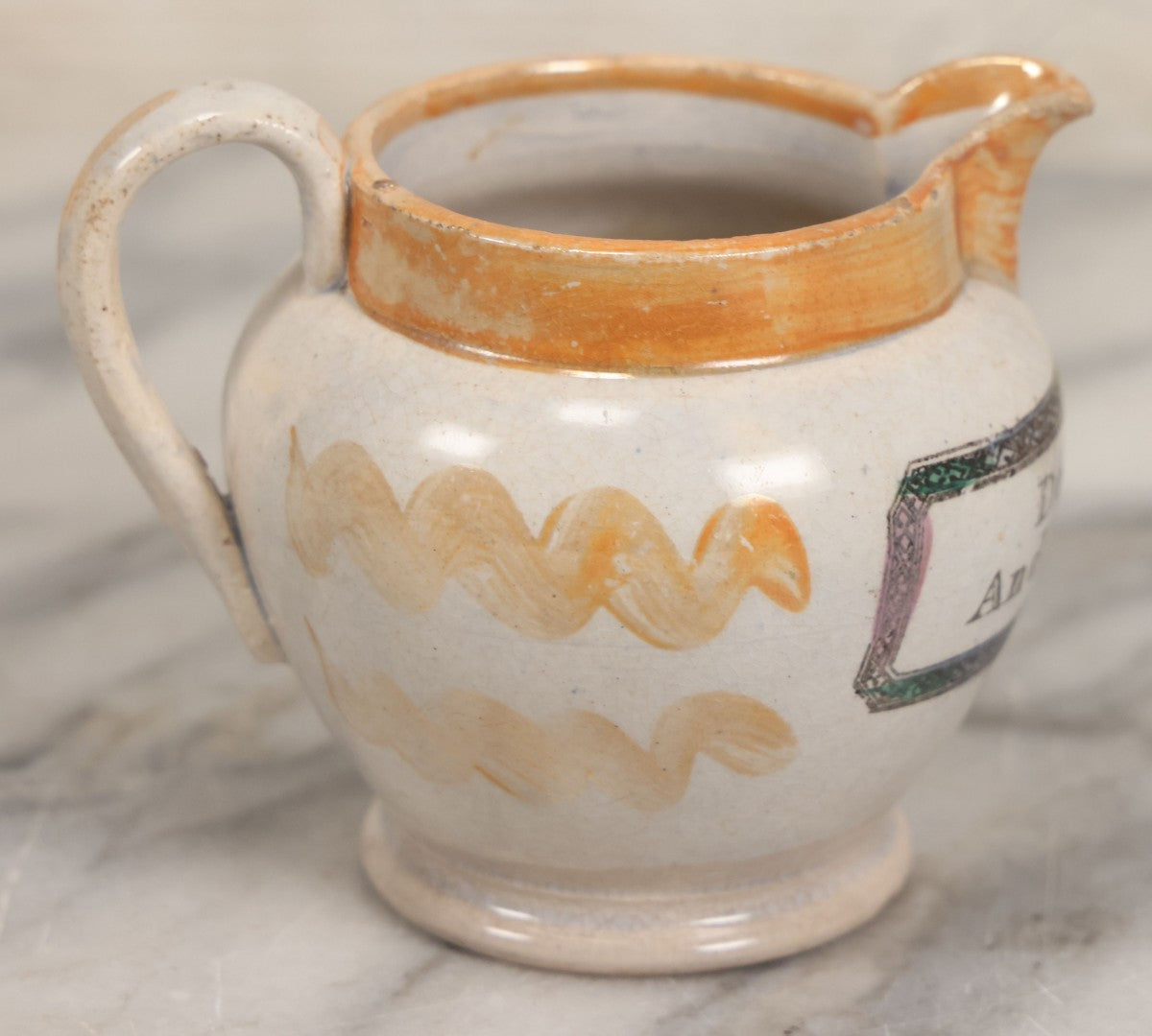 Lot 076 - Antique Hand Colored Transferware Creamer With "Do Thy Best, And Leave The Rest." Motto, Metallic Orange Paint On Sides, Handle And Rim, Unmarked, 3-3/8" H