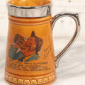 Lot 079 - Vintage Pottery Stein With "Home-Brew" Verse With Beer Chugging Man And "What's Yours?" Illustration On Verso, Metallic Painted Lip And Handle, Stamped Makers Mark Lord Nelson Pottery, England On Bottom, 5-1/4" H