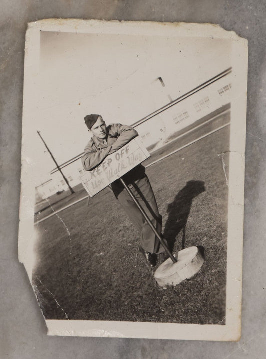 Lot 195 - Vintage Snapshot Photograph Of Soldier Smoking Pipe Leaning On (And Disobeying) "Keep Off / Use Walkway" Sign