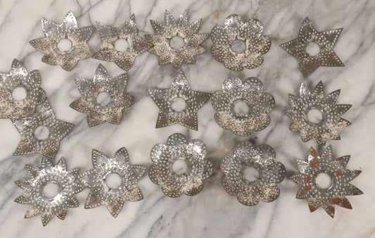 Lot 198 - Grouping Of 16 Pressed Tin Candle Wax Drip Holders In Starburst, Flower, And Star Designs