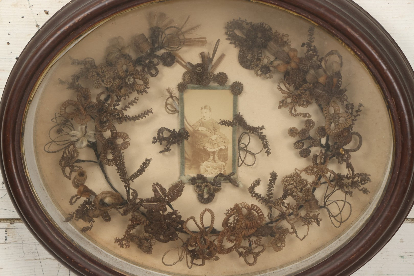 Lot 001 - Antique Victorian Mourning Memorial Human Hair Work Wreath In Deep Oval Shadowbox With Carte De Visite CDV Photograph Of Young Child In Blue Velvet Surround, 18-1/8" x 15-1/4"