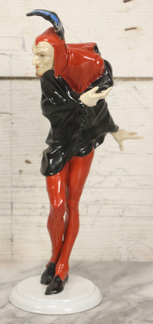 Lot 012 - Vintage Porcelain Mephisto (Mephistopheles) Figurine, By Karl Tutter For Hutschenreuther, Germany, Kunstabteilung, U.S. Zone Mark, Note Feather-On-Hat And Hood Repaired With Visible Glue, Circa 1955, 11-1/2" H