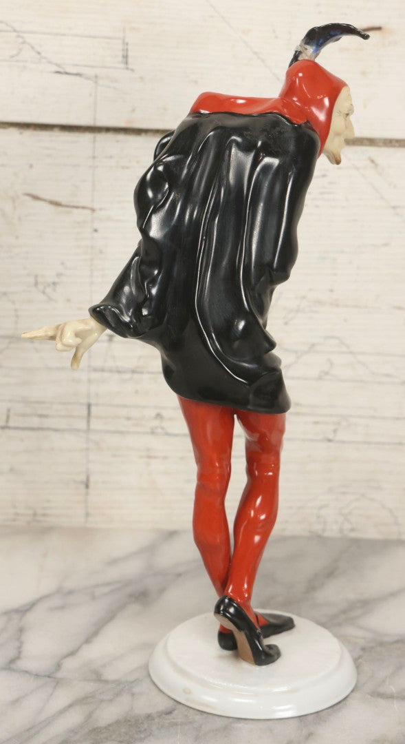 Lot 012 - Vintage Porcelain Mephisto (Mephistopheles) Figurine, By Karl Tutter For Hutschenreuther, Germany, Kunstabteilung, U.S. Zone Mark, Note Feather-On-Hat And Hood Repaired With Visible Glue, Circa 1955, 11-1/2" H