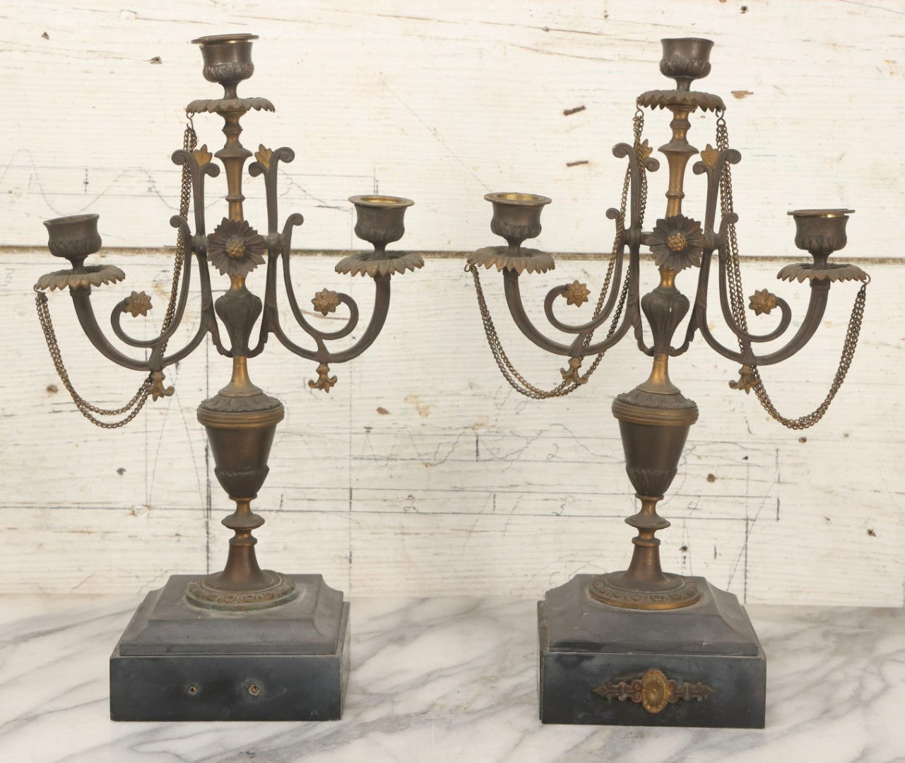 Lot 018 - Pair Of Antique Brass Three-Arm Candelabras With Floral Rosettes, Chains, And Ornate Ornamentation On Black Slate Bases, Circa 1850, 13-1/2" H Each