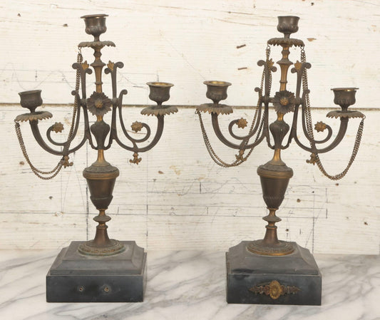 Lot 018 - Pair Of Antique Brass Three-Arm Candelabras With Floral Rosettes, Chains, And Ornate Ornamentation On Black Slate Bases, Circa 1850, 13-1/2" H Each