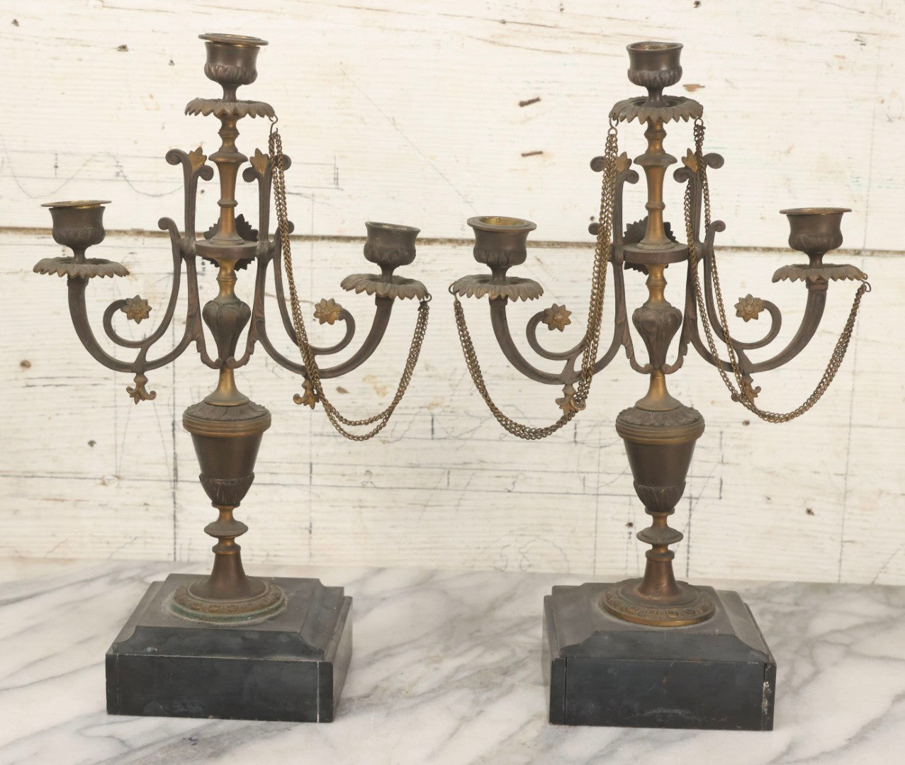 Lot 018 - Pair Of Antique Brass Three-Arm Candelabras With Floral Rosettes, Chains, And Ornate Ornamentation On Black Slate Bases, Circa 1850, 13-1/2" H Each