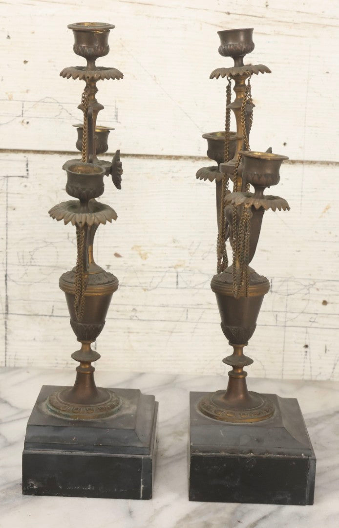 Lot 018 - Pair Of Antique Brass Three-Arm Candelabras With Floral Rosettes, Chains, And Ornate Ornamentation On Black Slate Bases, Circa 1850, 13-1/2" H Each