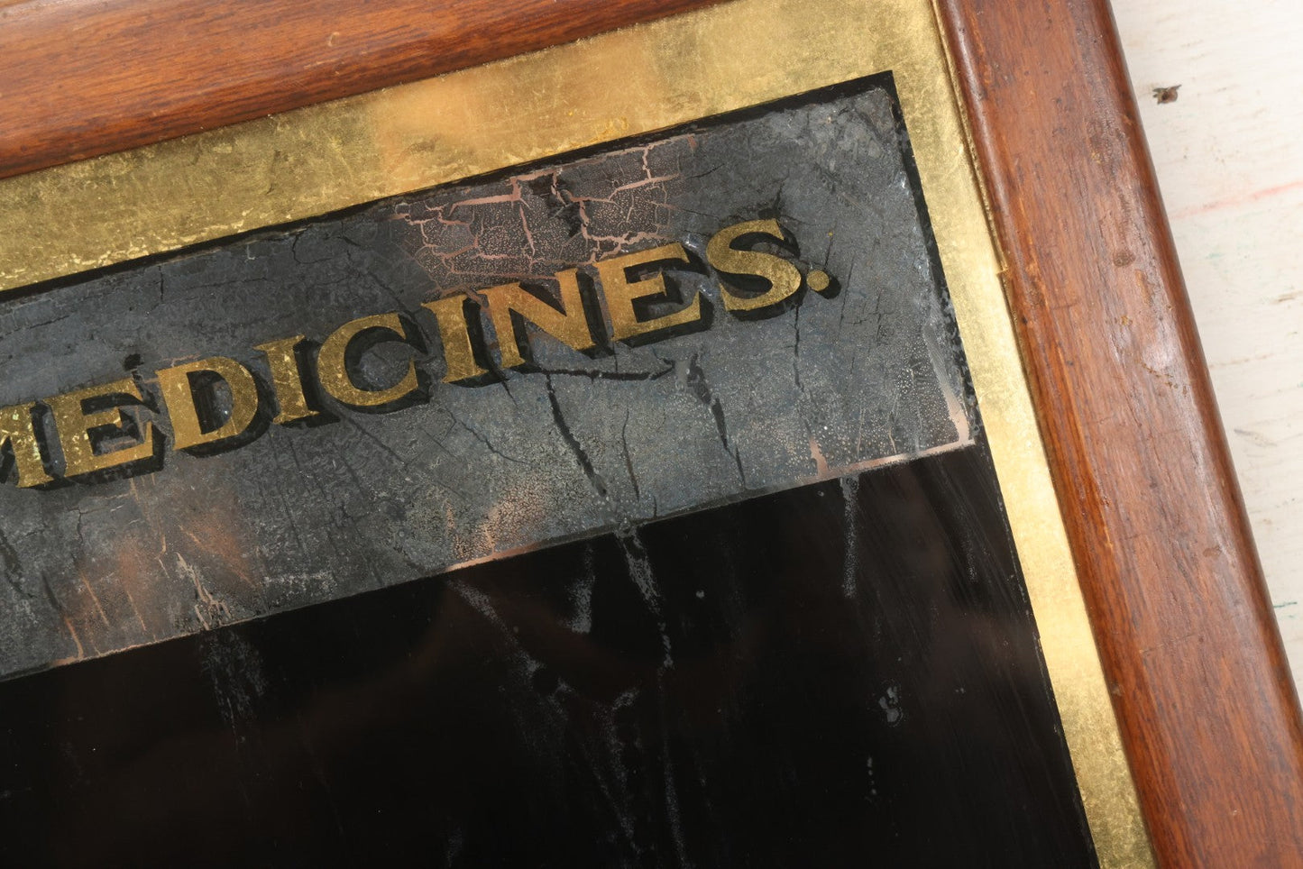 Lot 038 - Antique Reverse-Painted Glass Sign Panel Reading "Medicines." With Black Display Field And Gold Leaf Border, Possibly For Apothecary Or Doctor's Office, Framed, 14-1/4" x 19-1/4"