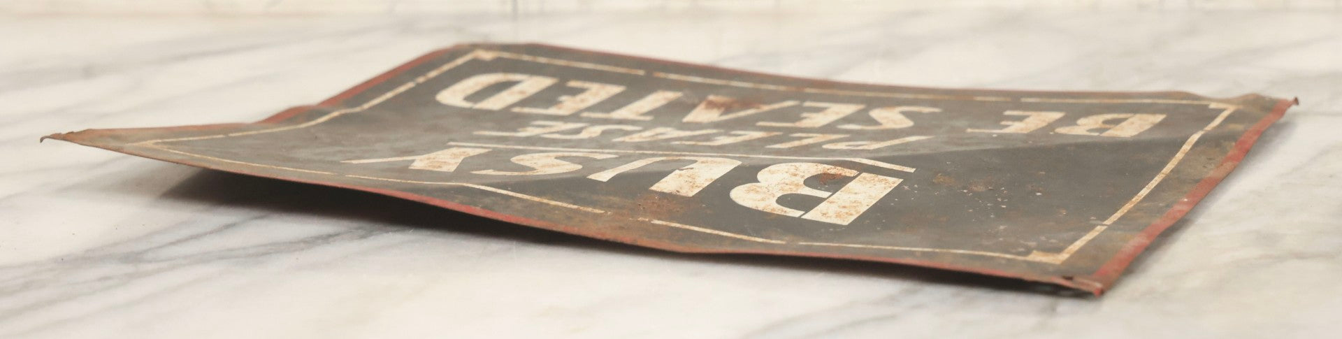 Lot 041 - Vintage Stenciled Tin Sign Reading "Busy — Please Be Seated," Black Field With White Lettering And Red Border, 10" x 8"