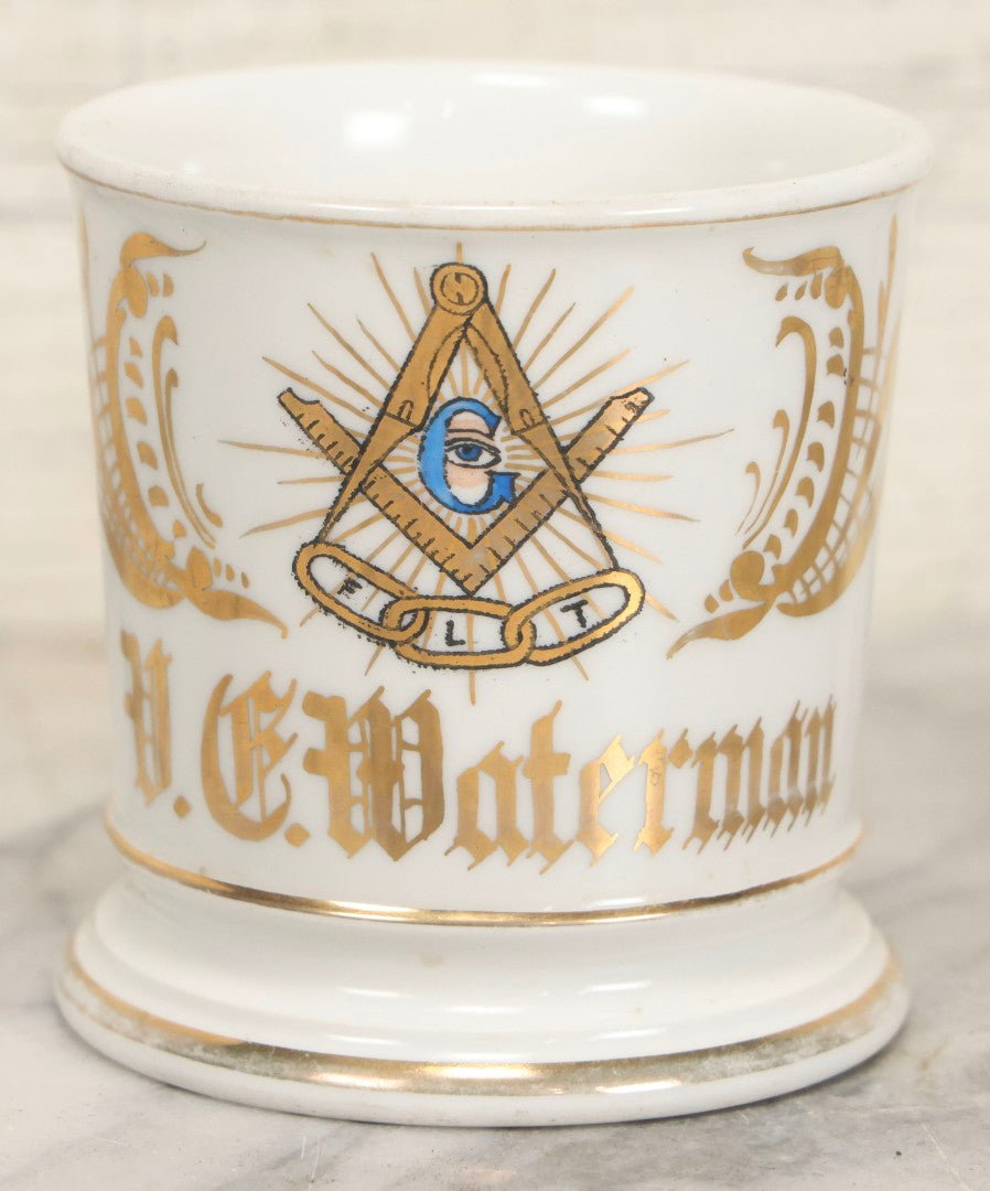 Lot 047 - Antique Hand-Decorated Porcelain Mug With Masonic Compass And Square, All-Seeing Eye, And Odd Fellows Three-Link F.L.T. Emblems, Belonging To V.E. Waterman, With Gold Painted Accents, T&V Limoges, France, 3-5/8" H
