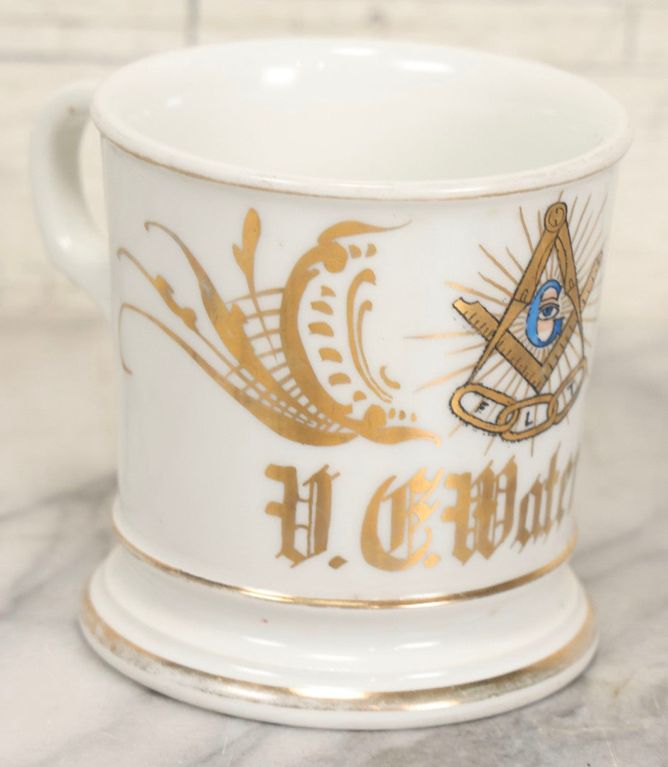 Lot 047 - Antique Hand-Decorated Porcelain Mug With Masonic Compass And Square, All-Seeing Eye, And Odd Fellows Three-Link F.L.T. Emblems, Belonging To V.E. Waterman, With Gold Painted Accents, T&V Limoges, France, 3-5/8" H