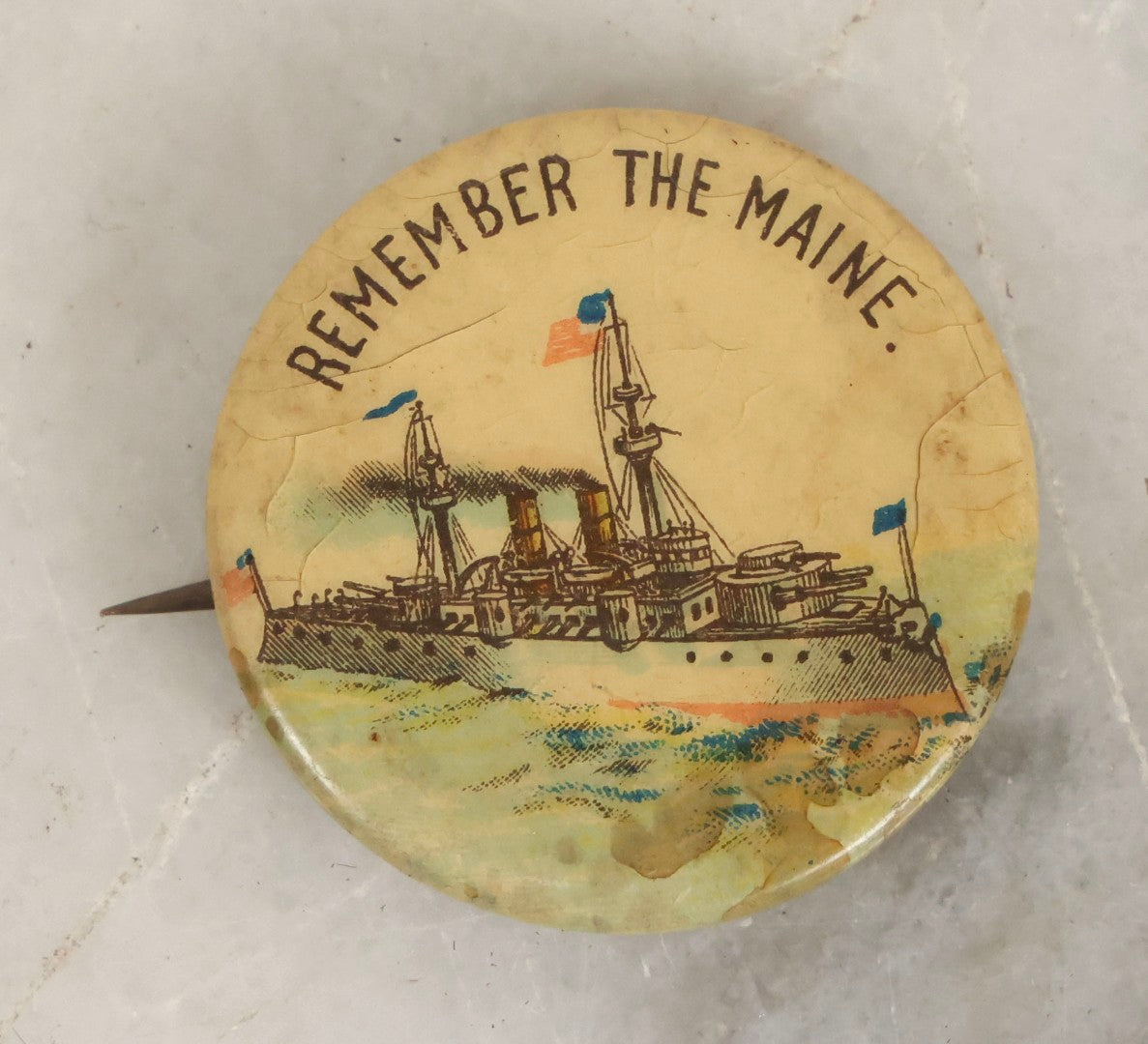 Lot 056 - Antique “Remember The Maine” Celluloid Pinback Button With Battleship, Whitehead & Hoag Co., Newark, New Jersey, Patent 1896, 1-1/4" Diameter