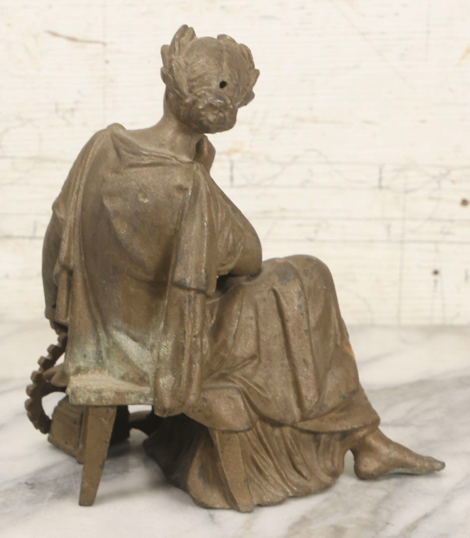 Lot 057 - Antique Cast Spelter Metal Clock Topper Statue With Bronze Wash Depicting Goddess-Like Woman Beside Gear, Anvil, And Blacksmith's Hammer, 8-1/2" H