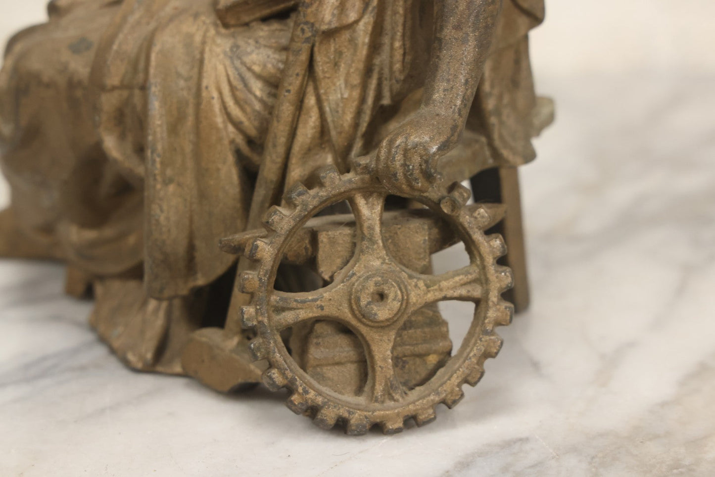 Lot 057 - Antique Cast Spelter Metal Clock Topper Statue With Bronze Wash Depicting Goddess-Like Woman Beside Gear, Anvil, And Blacksmith's Hammer, 8-1/2" H