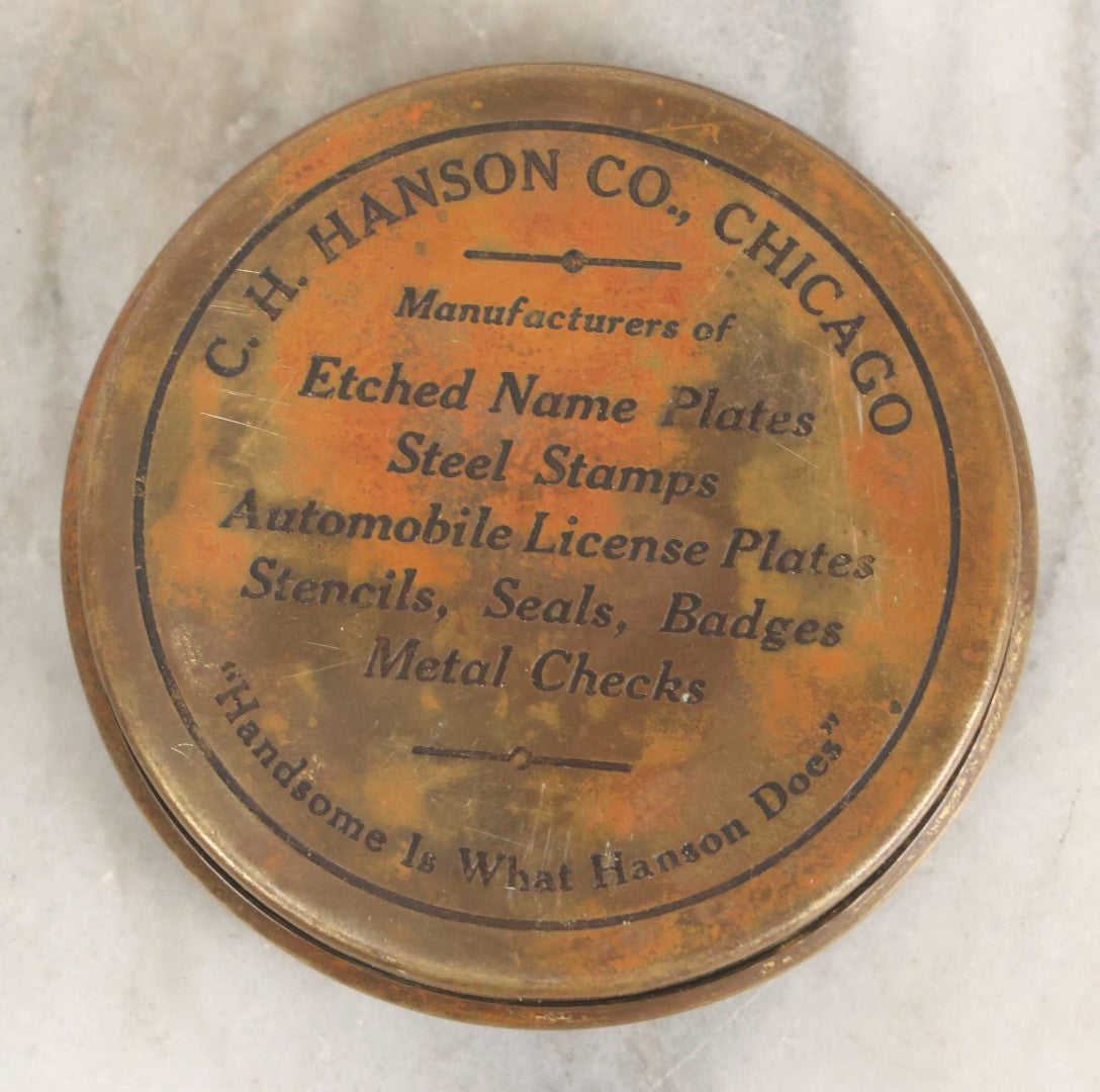 Lot 063 - Antique 1921 C. H. Hanson Co. Chicago Brass Advertising Paperweight With Ornate Crest And Motto "Handsome Is What Hanson Does," 3-3/8" Diameter