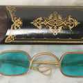 Lot 065 - Antique Brass Frame Eyeglasses With Blue-Green Tinted Lenses And Folding Side Extensions, In Black Lacquered Papier-Mâché Case With Gilt Detailing