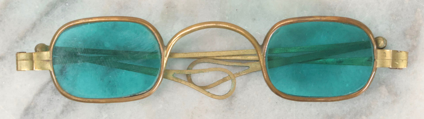 Lot 065 - Antique Brass Frame Eyeglasses With Blue-Green Tinted Lenses And Folding Side Extensions, In Black Lacquered Papier-Mâché Case With Gilt Detailing