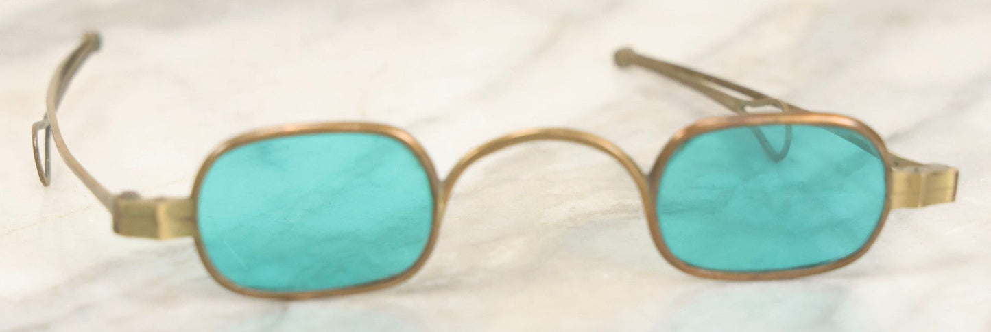 Lot 065 - Antique Brass Frame Eyeglasses With Blue-Green Tinted Lenses And Folding Side Extensions, In Black Lacquered Papier-Mâché Case With Gilt Detailing