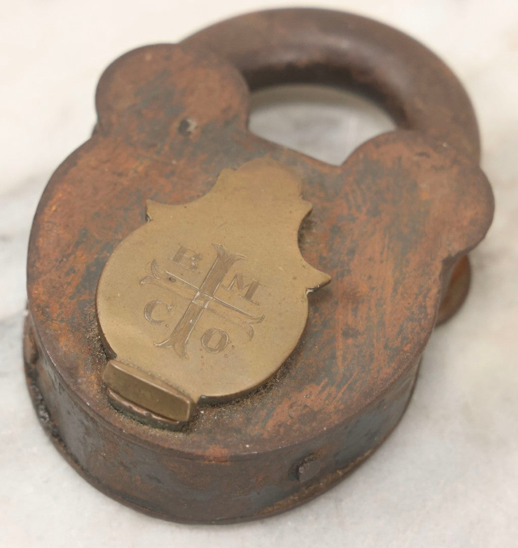 Lot 072 - Antique Cast Iron And Brass Padlock Marked “B.M.Co.” With Cross Motif On Brass Cover, Unlocked, No Key