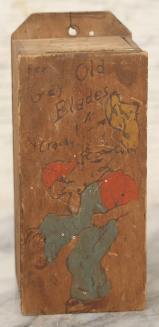 Lot 080 - Antique Folk Art Hand-Painted Pyrography Razor Blade Wall Box Inscribed “Fer Old Gay Blades 'Cracky!'”, Depicting Dancing Bearded Man, Fort Benning, Georgia, With Faint “Old Razor Blades” Text On Lid, In Red, Blue, And Yellow Paint