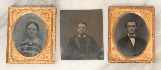 Lot 165 - Grouping Of Three Antique Portrait Photographs, One Tintype Of A Young Man, Two Ruby Ambrotypes In Brass Mats Including Young Woman With Hand-Painted Jewelry And Young Man In Bowtie