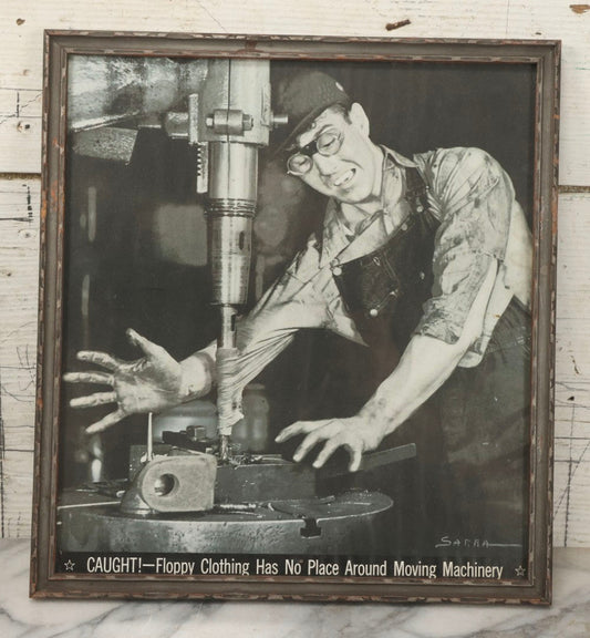 Lot 233 - Vintage Industrial Safety Photograph “Caught!—Floppy Clothing Has No Place Around Moving Machinery,” Signed Sarra, In Gray Painted Frame, 11-1/8" x 12-1/8"
