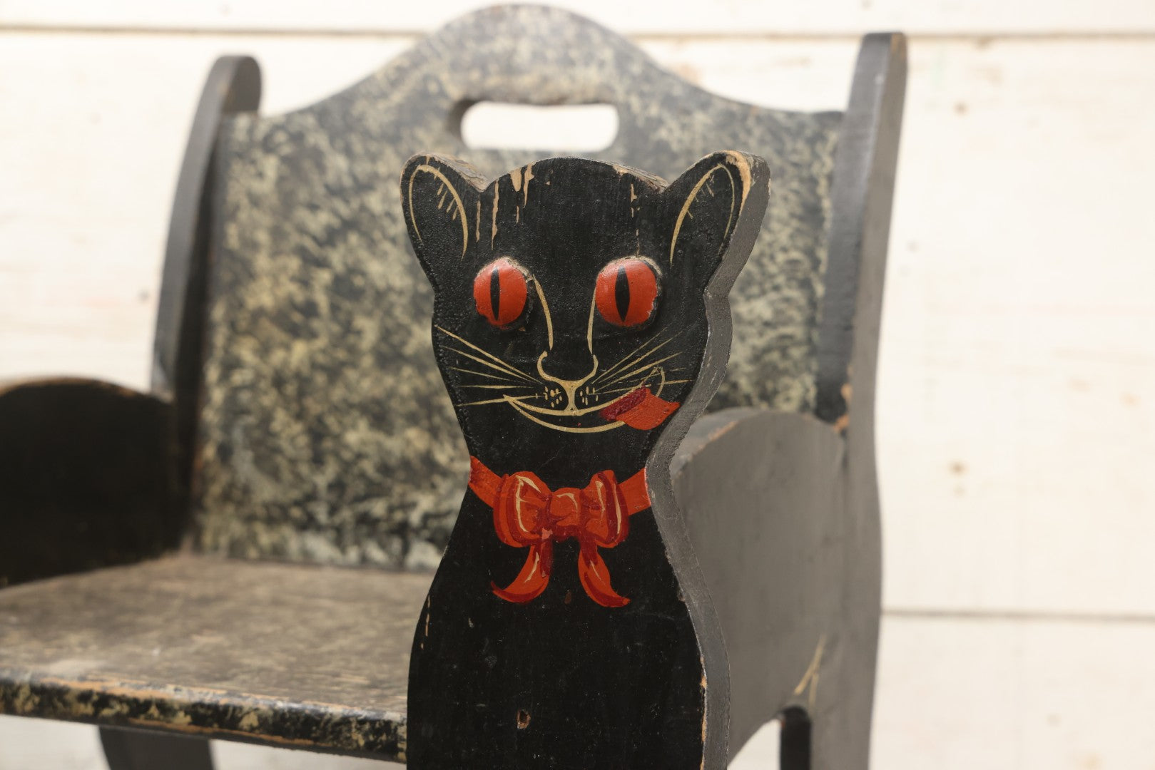 Lot 001 - Vintage Folk Art Wooden Black Cat Child's Seat With Red Bow Ties And Domed Eyes, Hand Painted With Sponge Painted Texture Finish, Circa 1930s