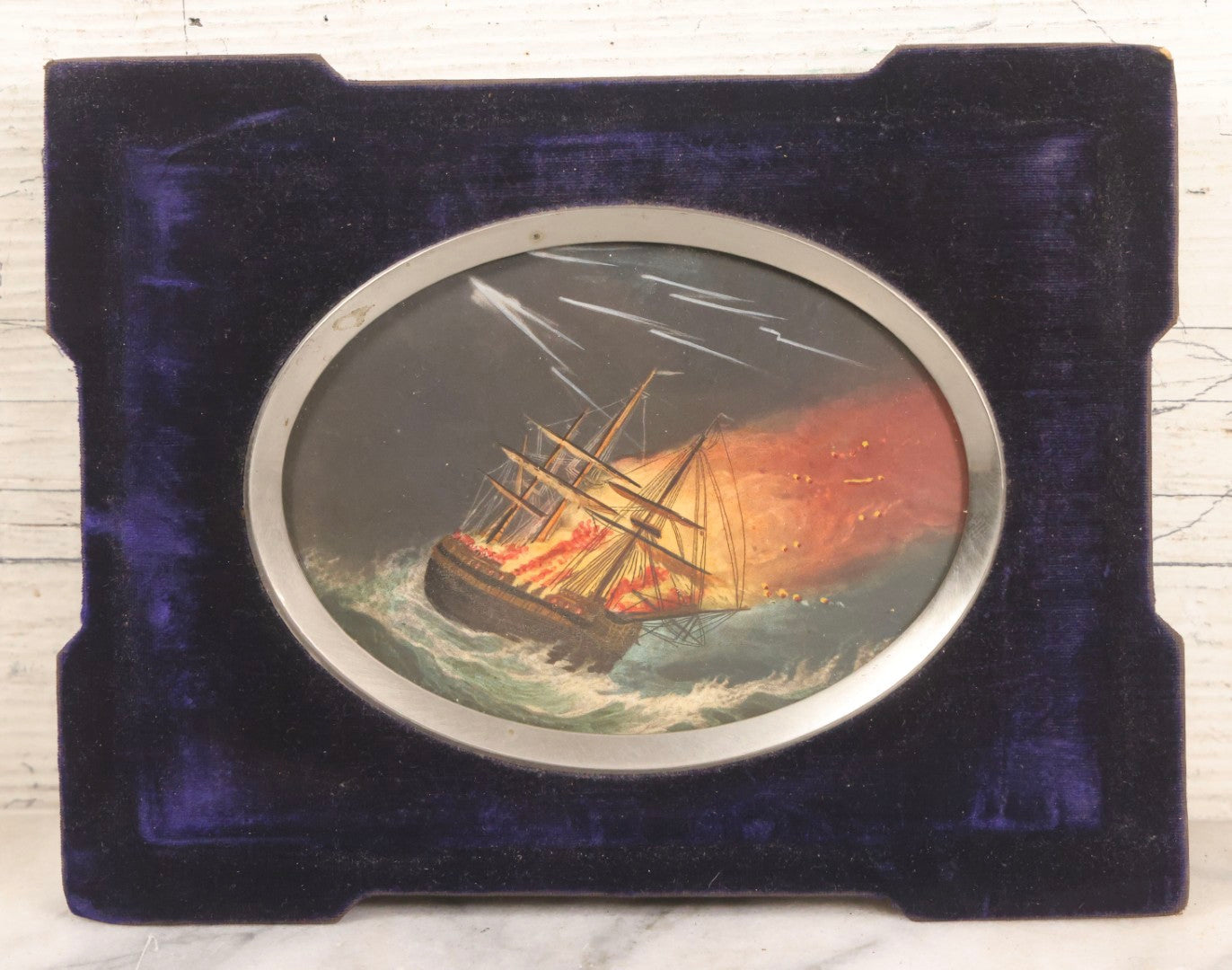 Lot 055 - Antique Hand-Colored Engraving Of Ship On Fire In Storm With Lightning, In Victorian Purple Velvet Frame With Silver Metal Surround, 8-1/2" x 6-1/2"