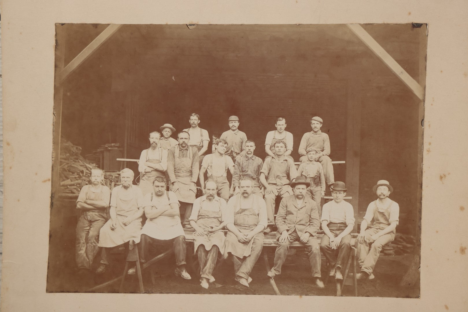 Lot 109 - Antique Boarded Occupational Photograph Of Lumberyard Workers In Work Clothes Posed Atop Stacked Lumber On Sawhorses Before Piles Of Wood