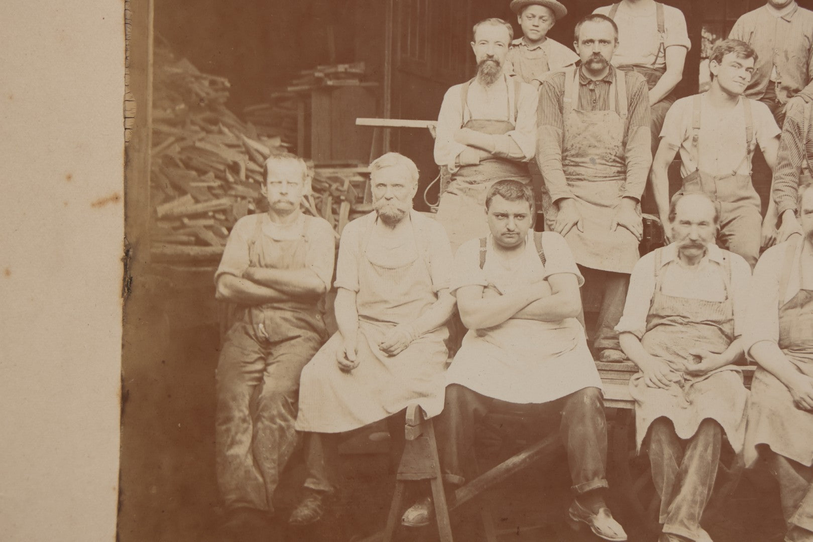 Lot 109 - Antique Boarded Occupational Photograph Of Lumberyard Workers In Work Clothes Posed Atop Stacked Lumber On Sawhorses Before Piles Of Wood